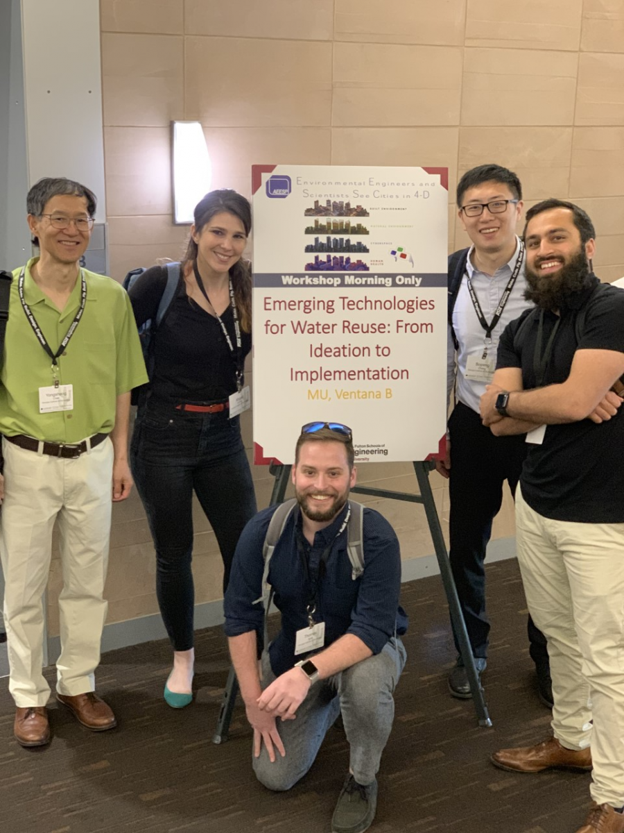 Chen and team posed in front of a poster (photo) 