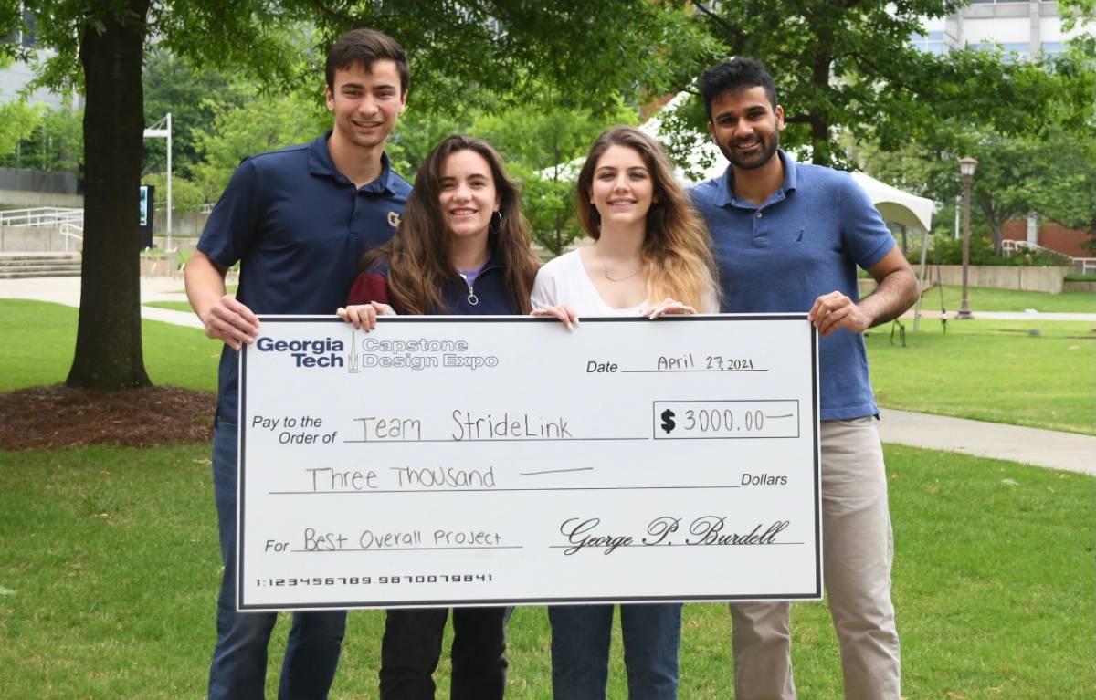 The members of StrideLink with an oversized check from their Capstone win