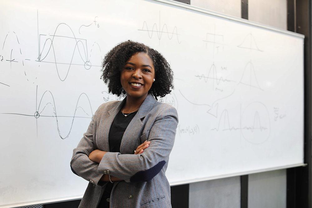 Quinnell Smith standing in front of a white board, photo