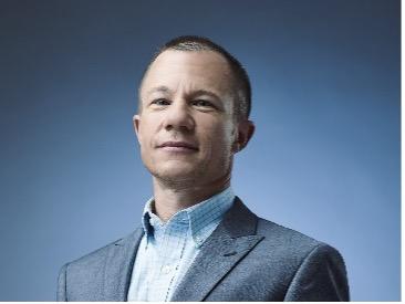 Todd Whitmore in front of blue background